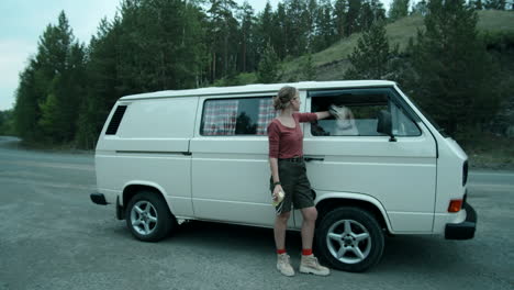 Woman-Standing-by-Van-and-Petting-Dog